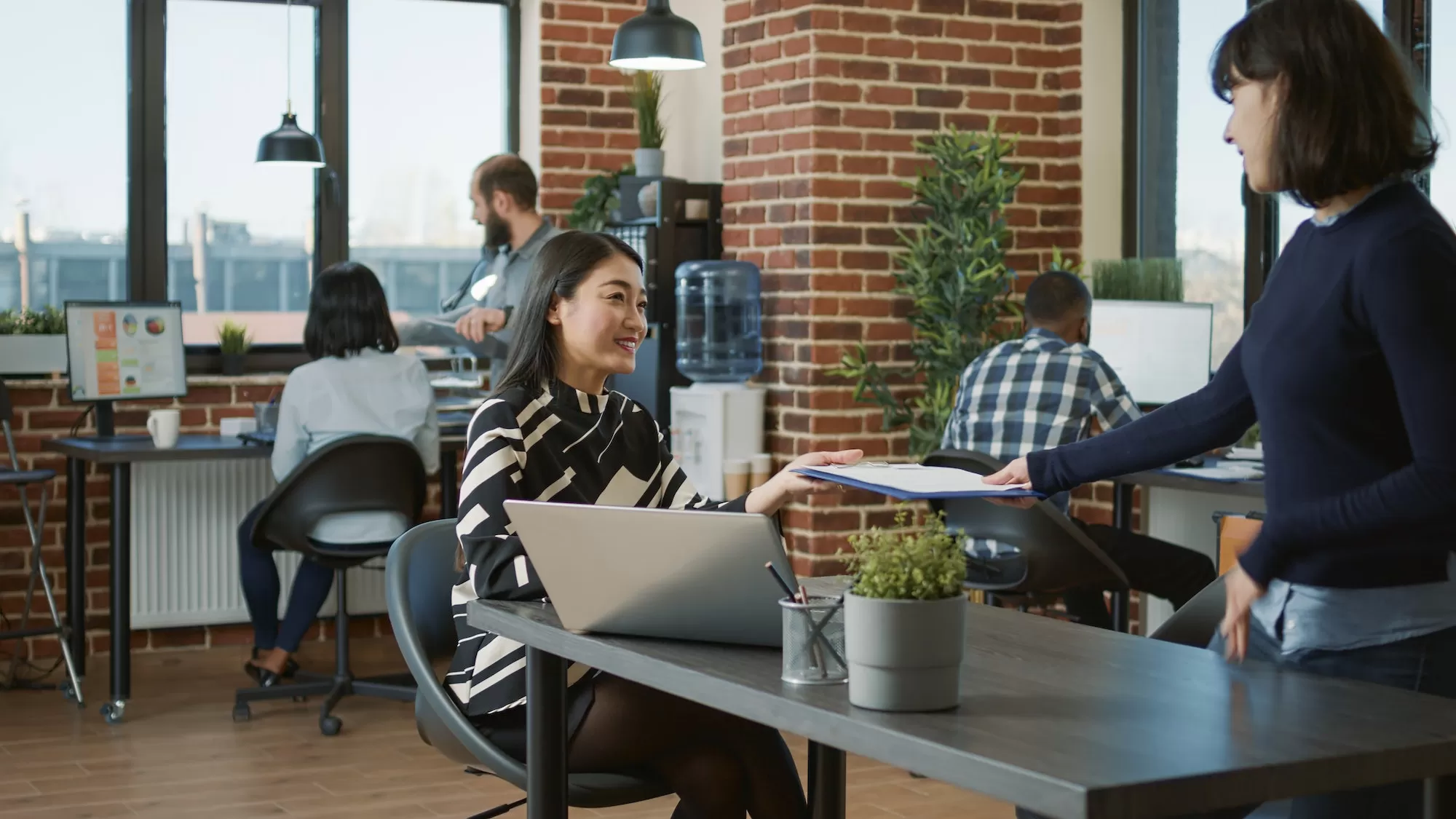 Colleagues collaborating and reviewing documents in a modern open-plan office